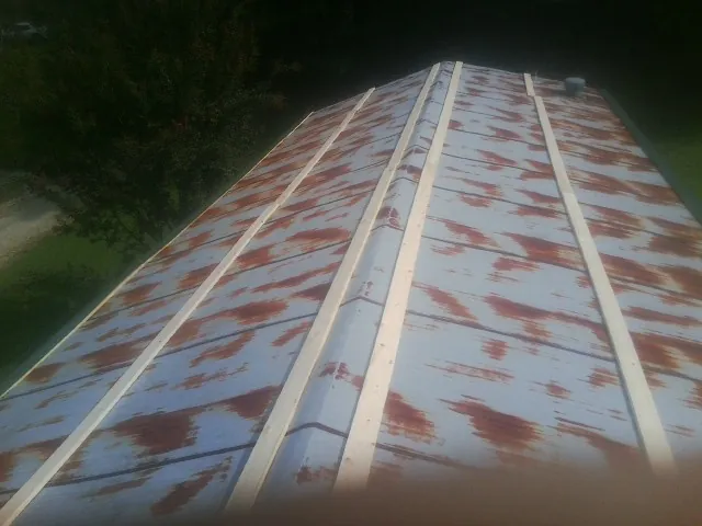 Rusted metal roof panels with new wood purlins before replacement — Storm Damage Roof Repair in Basehor by Roofing Brothers