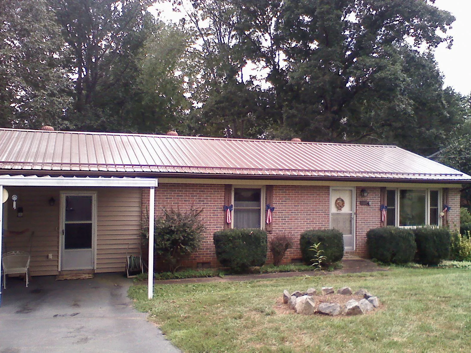 Bronze metal roof and carport on a brick ranch home — Roof Repair work by our crew in Basehor